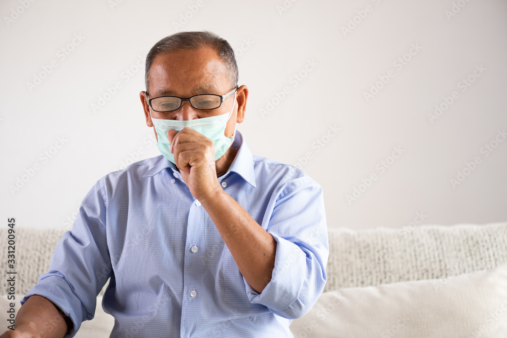 Asian old man wearing Protective face mask and cough, get ready for Coronavirus and pm 2.5 fighting, sitting on sofa at home. Senior healthcare concept. Asian old man wearing Protective face mask and cough, get ready for Coronavirus and pm 2.5 fighting, sitting on sofa at home. Senior healthcare concept.