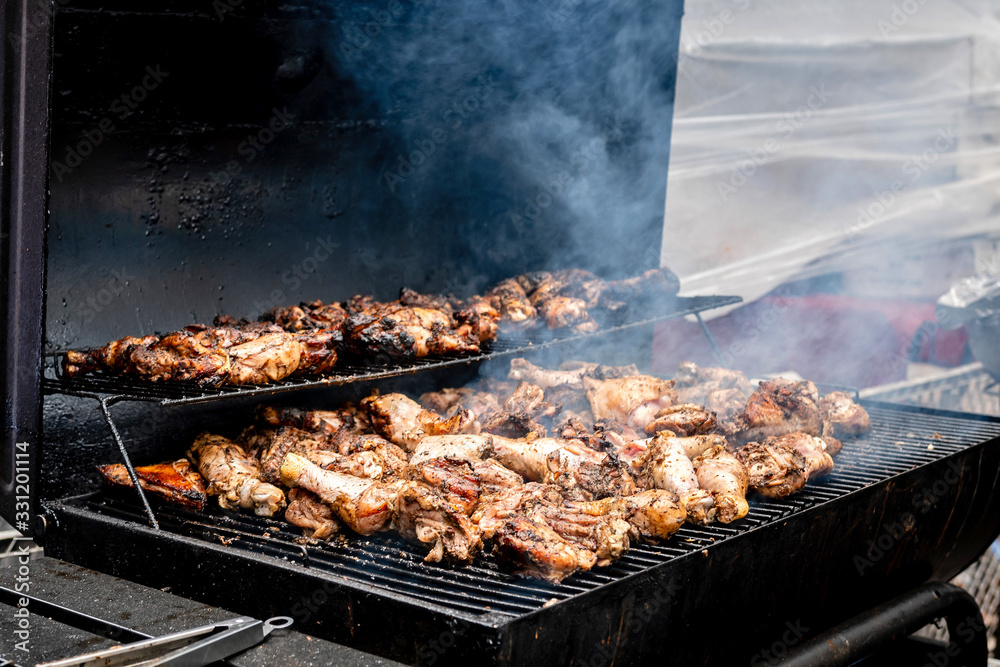 Grilled chicken legs and thigh over flames on a barbecue