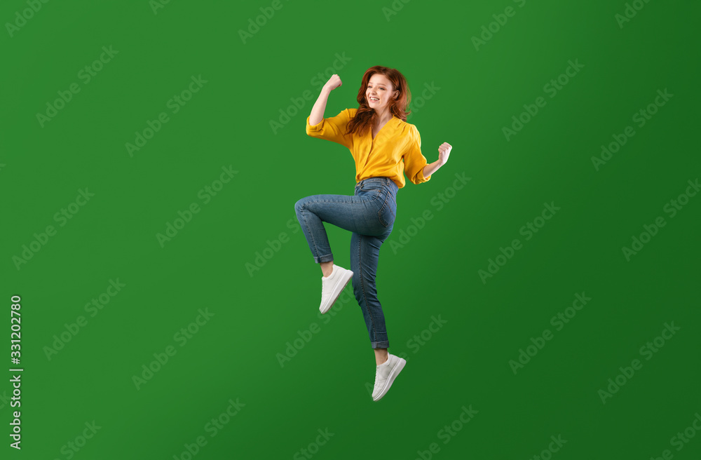 Happy Millennial Girl Jumping Shaking Fists, Studio Shot