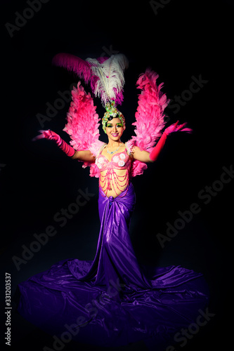 Beautiful Cabaret Show woman Dancer dress in pink feather with smiling on black background