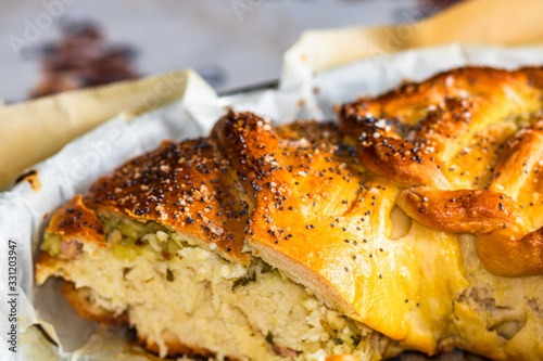 Close up photo with selective focus on details of salt and poppy seeds over a braided puff pastry. photo