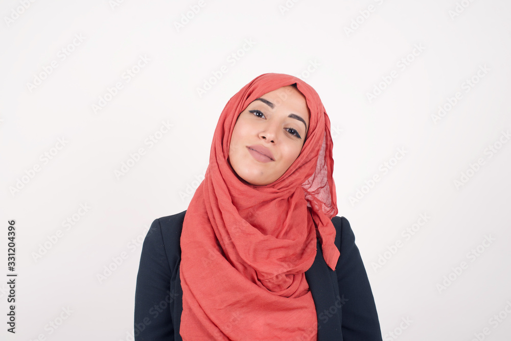 Beautiful smiling brunette female with broad smile, shows white teeth, wears casual t shirt, stands over gray studio wall rejoices having day off. Woman standing indoors. Beautiful smiling brunette female with broad smile, shows white teeth, wears casual t shirt, stands over gray studio wall rejoices having day off. Woman standing indoors.