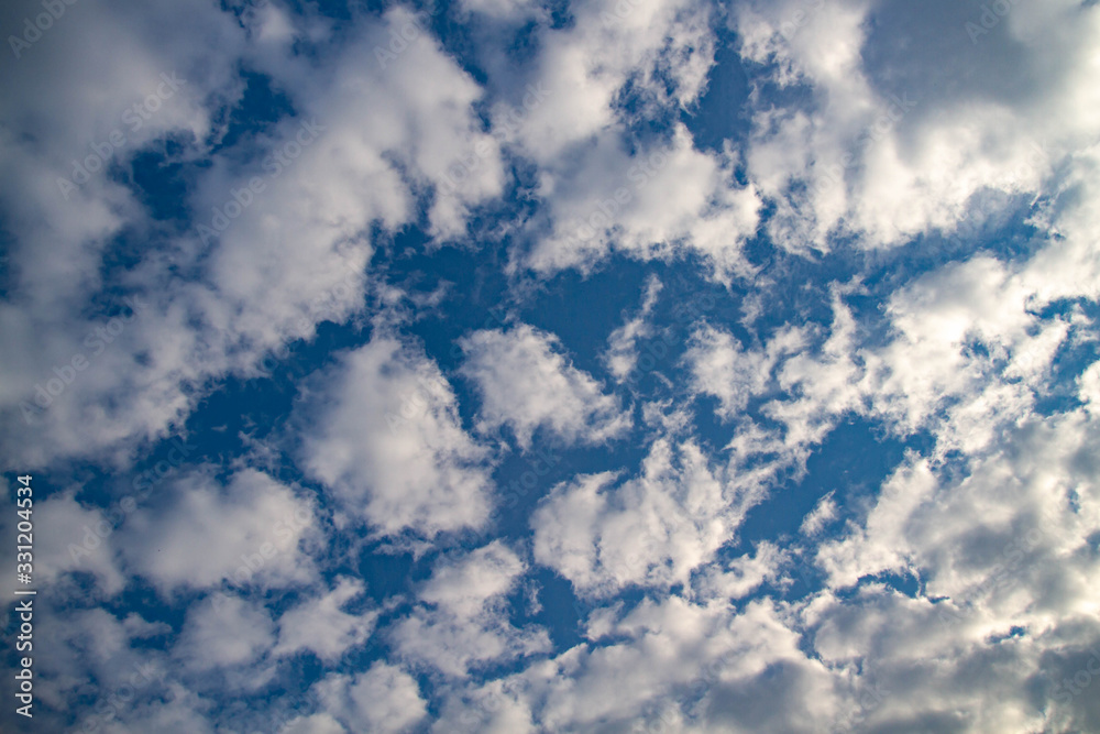 The sky is covered with small clouds. The sun shines through the clouds. Sunny day. Beautiful background. The sky is covered with small clouds. The sun shines through the clouds. Sunny day. Beautiful background.