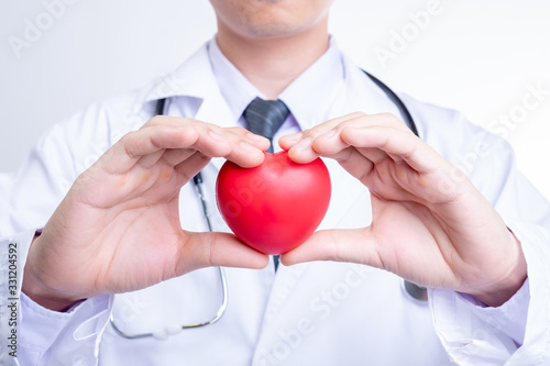 Asian doctor holding a red heart ball.Concept of health care and medical.