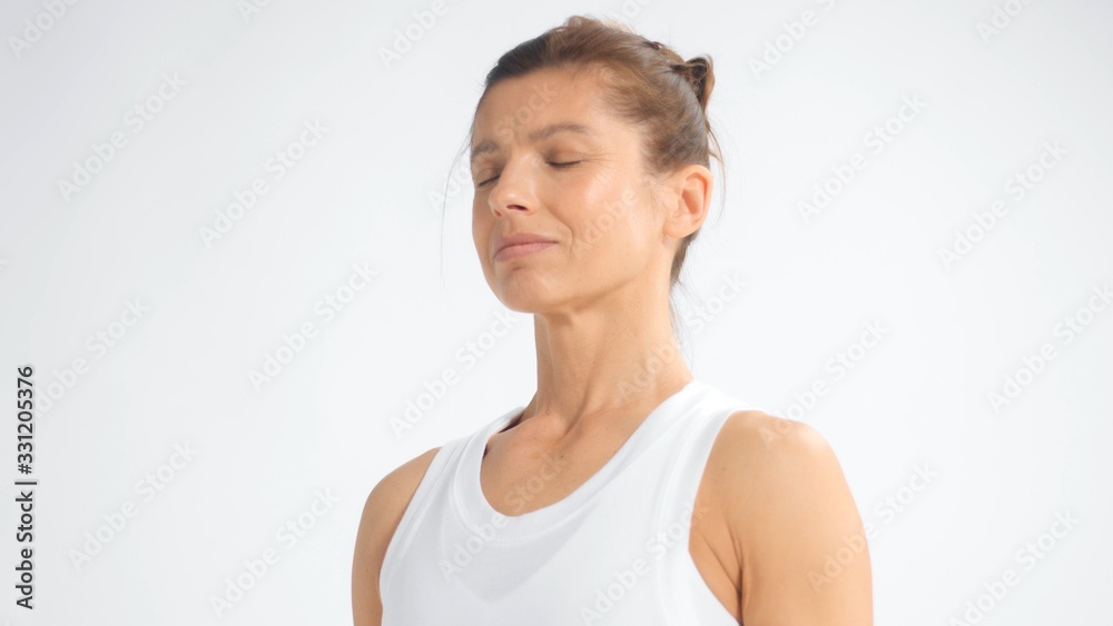 Senior woman in white space practice yoga Closeup portrait with eyes closed head in prifile Senior woman in white space practice yoga Closeup portrait with eyes closed head in prifile