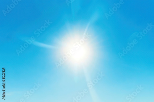 Bright sun flares in the clear blue sky. Star in space. Nature background. Energy and power