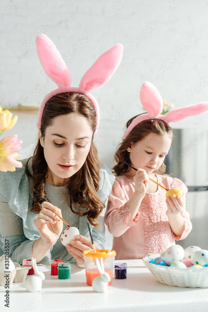 selective focus of mother and kid in bunny ears painting chicken eggs selective focus of mother and kid in bunny ears painting chicken eggs