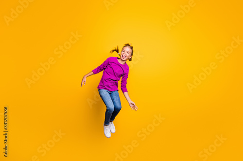 Full length body size view of her she nice attractive lovely childish playful cheerful cheery girl jumping grimacing fooling having fun isolated on bright vivid shine vibrant yellow color background