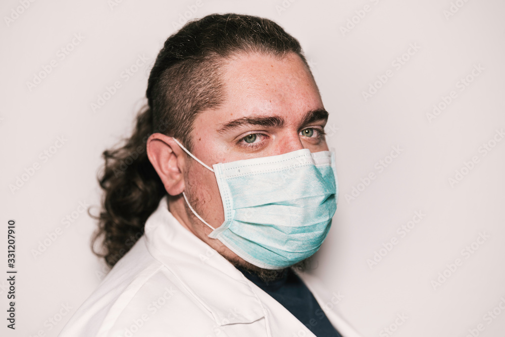 Medical stock photography wearing blue mask and white coat with green eyes. Medical stock photography wearing blue mask and white coat with green eyes.