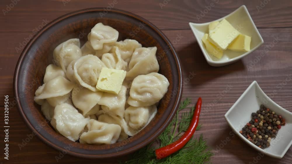 Рomemade cooked russian dumplings lie in a plate. Dumplings, pelmeni, ravioli o a brown plate. Bowl of homemade boiled dumplings with butter. Traditional Russian dish pelmeni filled with meat. Рomemade cooked russian dumplings lie in a plate. Dumplings, pelmeni, ravioli o a brown plate. Bowl of homemade boiled dumplings with butter. Traditional Russian dish pelmeni filled with meat.