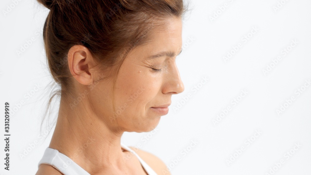 Senior woman in white space practice yoga Closeup portrait watching to the camera and smiling on white Senior woman in white space practice yoga Closeup portrait watching to the camera and smiling on white