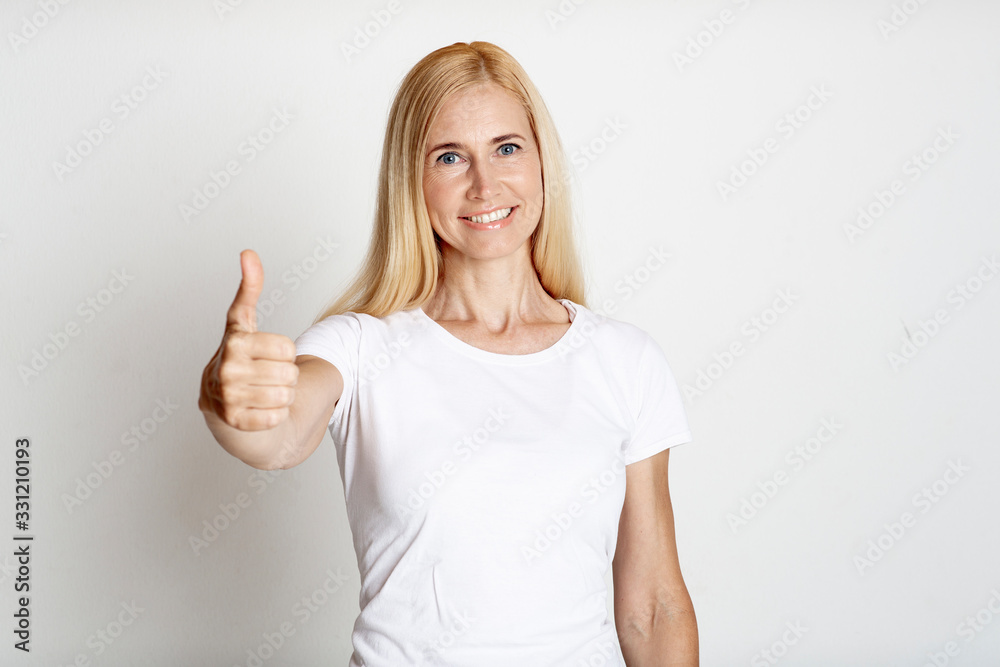Portrait of mature smiling woman showing thumb up Portrait of mature smiling woman showing thumb up