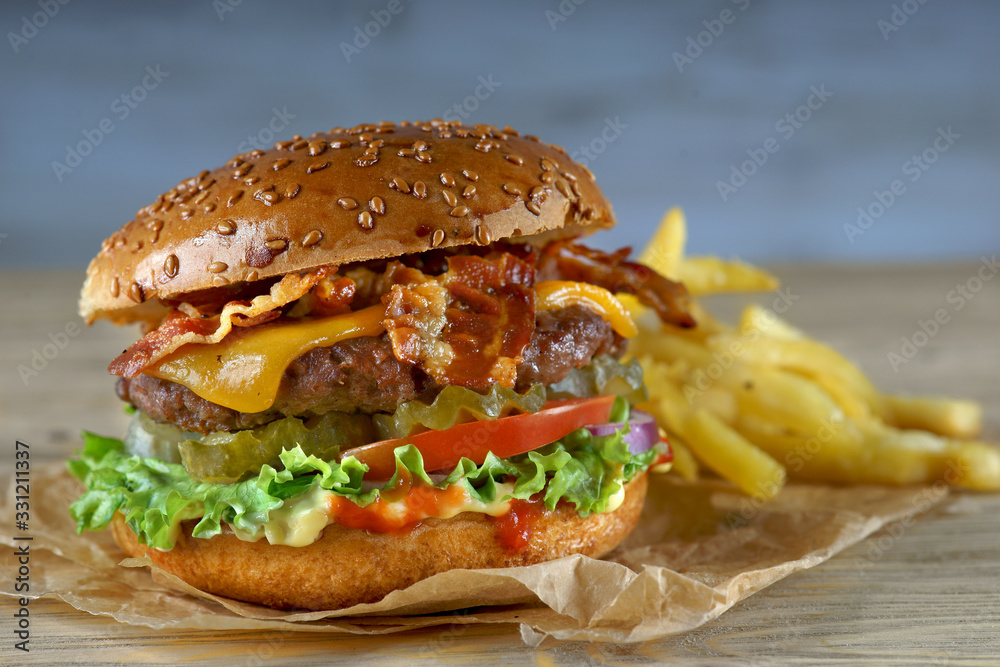 Burger with bacon, cheese and fried potatoes Burger with bacon, cheese and fried potatoes