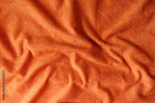 Crumpled bright reddish orange artificial suede fabric