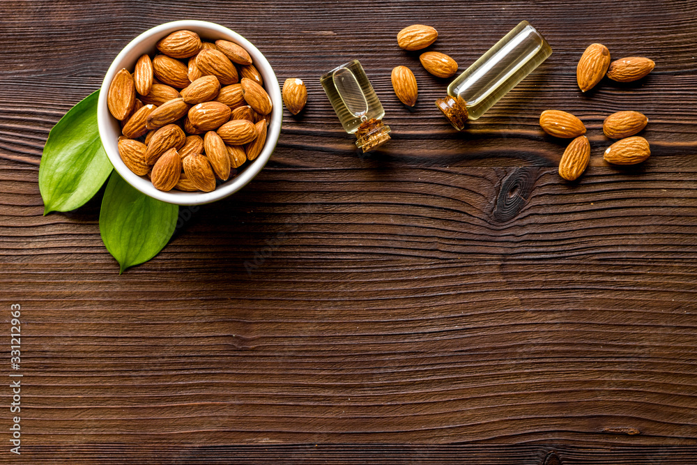 Spa and aromatherapy. Almond oil in small bottles on wooden background top-down copy space Spa and aromatherapy. Almond oil in small bottles on wooden background top-down copy space