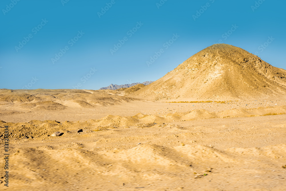 Safari in Egypt Sinai, travel of tourists in the Sahara desert.Road in the desert. Yellow sand and blue sky.