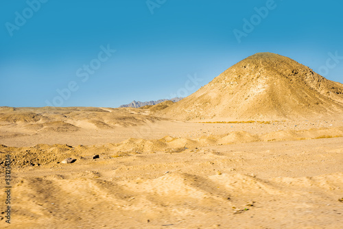 Safari in Egypt Sinai  travel of tourists in the Sahara desert.Road in the desert. Yellow sand and blue sky.