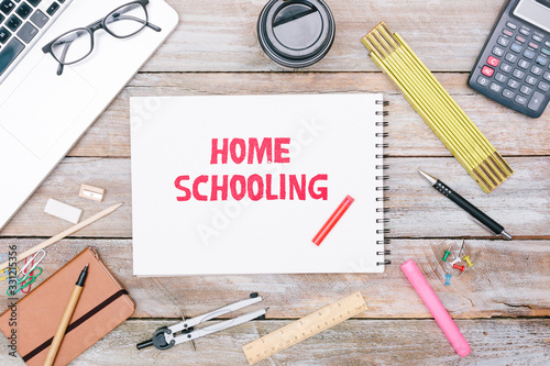 Home Schooling written in notepad on table, pencil for writing, grunge office deskt flat lay shot from above photo