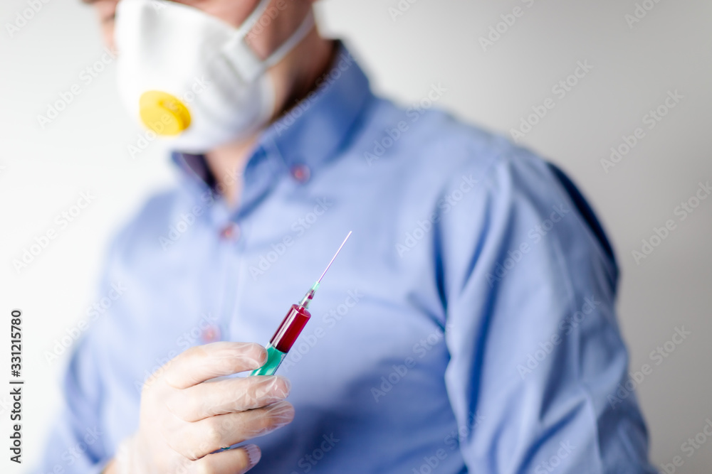 Pandemia COVID-19, lekarz w masce trzymający strzykawke na testy Pandemia COVID-19, lekarz w masce trzymający strzykawke na testy