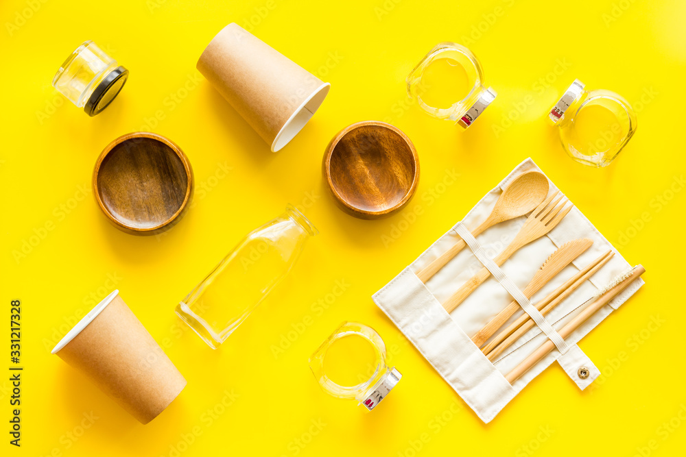 Set of eco friendly bamboo tableware, cotton bag, paper mug and glass jars. Sustainable lifestyle, plastic free concept on yellow table - top view Set of eco friendly bamboo tableware, cotton bag, paper mug and glass jars. Sustainable lifestyle, plastic free concept on yellow table - top view