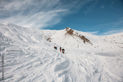 People with ski equipment climb the mountain to make freeride.