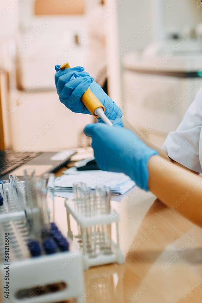 Blood test process in laboratory. Doctor hands making blood test. Many blood test-tubes with blood on the table. Covid-19 testing. Blood test process in laboratory. Doctor hands making blood test. Many blood test-tubes with blood on the table. Covid-19 testing.