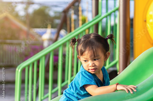 Portrait image of 1-2 yeas old baby. Happy Asian child girl smiling and laughing. She playing with slider bar toy at the playground. Learning and active of kids concept.