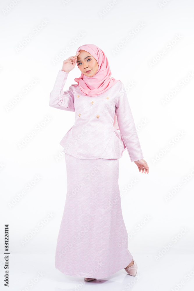 Full length portrait of a beautiful female model wearing traditional dress and hijab, a lifestyle apparel for Muslim women isolated on white background. Idul Fitri and hijab fashion concept. Full length portrait of a beautiful female model wearing traditional dress and hijab, a lifestyle apparel for Muslim women isolated on white background. Idul Fitri and hijab fashion concept.