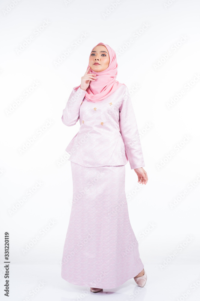 Full length portrait of a beautiful female model wearing traditional dress and hijab, a lifestyle apparel for Muslim women isolated on white background. Idul Fitri and hijab fashion concept. Full length portrait of a beautiful female model wearing traditional dress and hijab, a lifestyle apparel for Muslim women isolated on white background. Idul Fitri and hijab fashion concept.