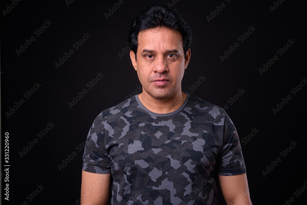 Obraz premium Mature handsome Indian man against black background