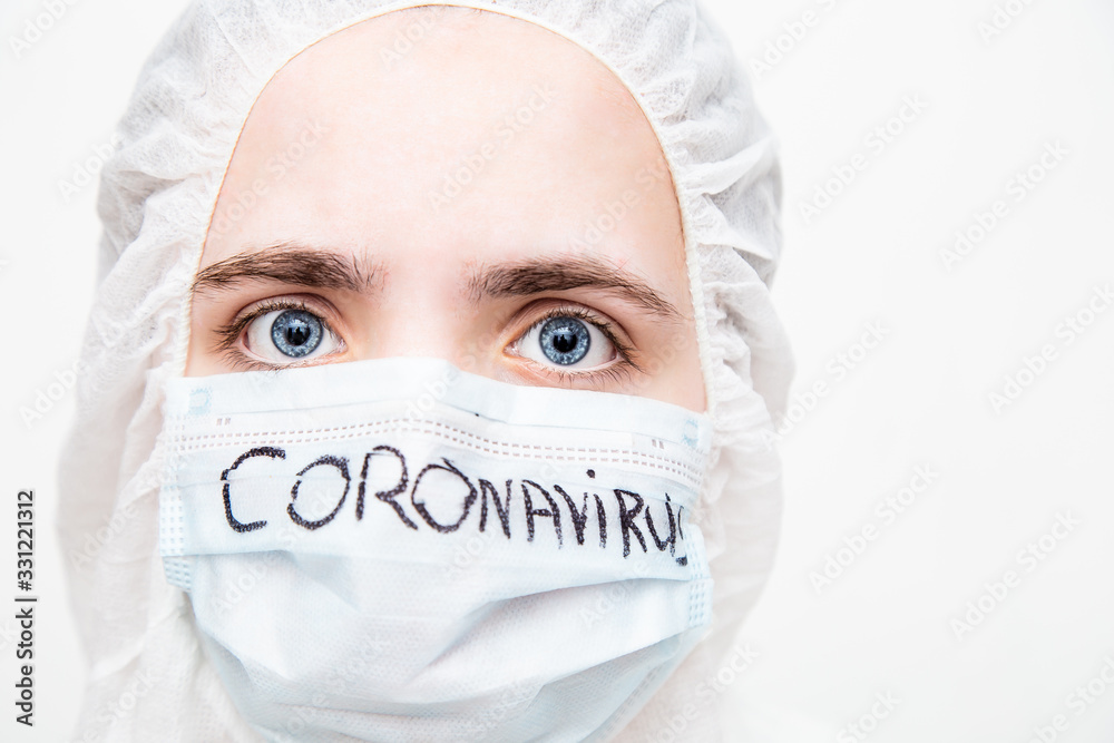 A virologist in a virus- proof suit and medical mask reflects on the consequences of the coronavirus epidemic. The doctor is thinking how to stop the virus. fear in the eyes A virologist in a virus- proof suit and medical mask reflects on the consequences of the coronavirus epidemic. The doctor is thinking how to stop the virus. fear in the eyes