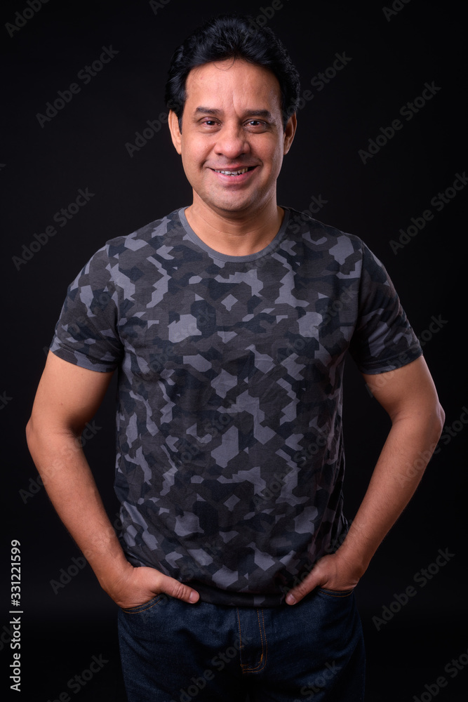 Mature handsome Indian man against black background