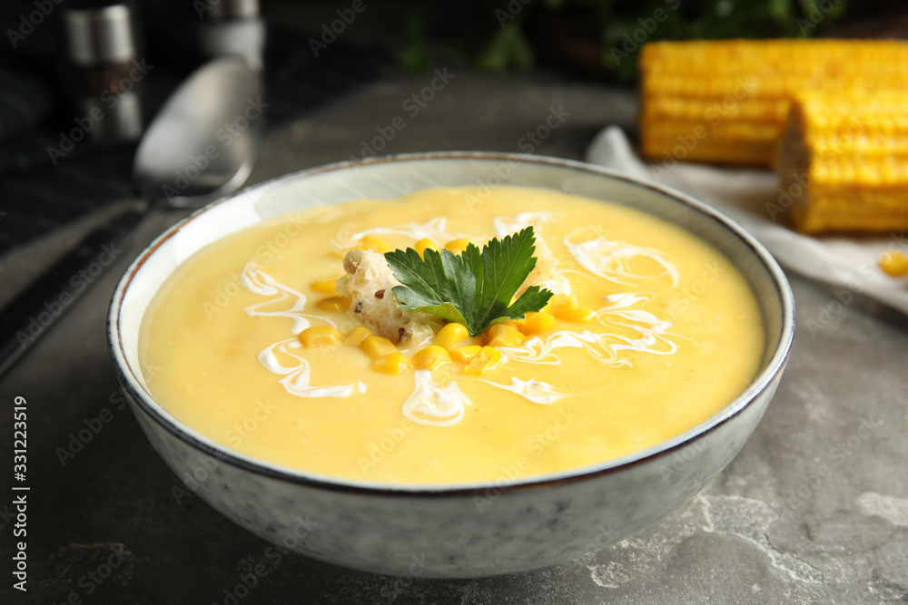 Delicious corn cream soup served on grey table, closeup Delicious corn cream soup served on grey table, closeup