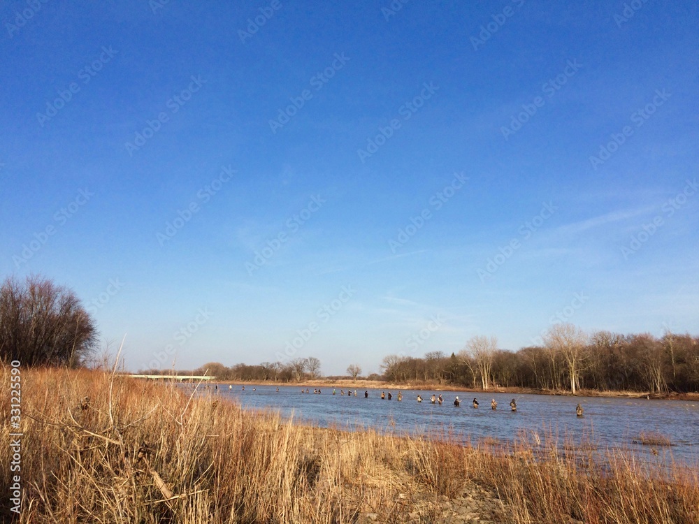 fishermen wading in the river