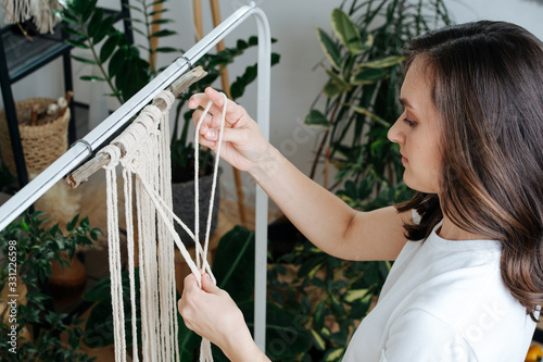 Girl at work on weaving knots macrame photo