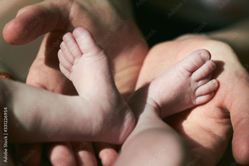 The mother hold feets of newborn baby The mother hold feets of newborn baby