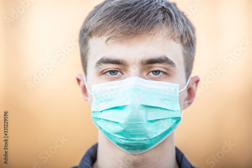 Young man with protective mask on his face. Protection against virus dust or smog. Coronavirus Covid-19 concept