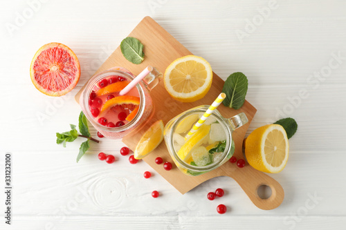 Glass jars with lemonade on wooden background. Fresh drink