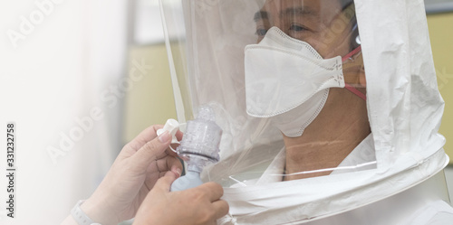 Respirator fit test prepared for COVID-19. Asia man testing repiratory system with N-95 surgical mask to checks properly fits face to wears. photo