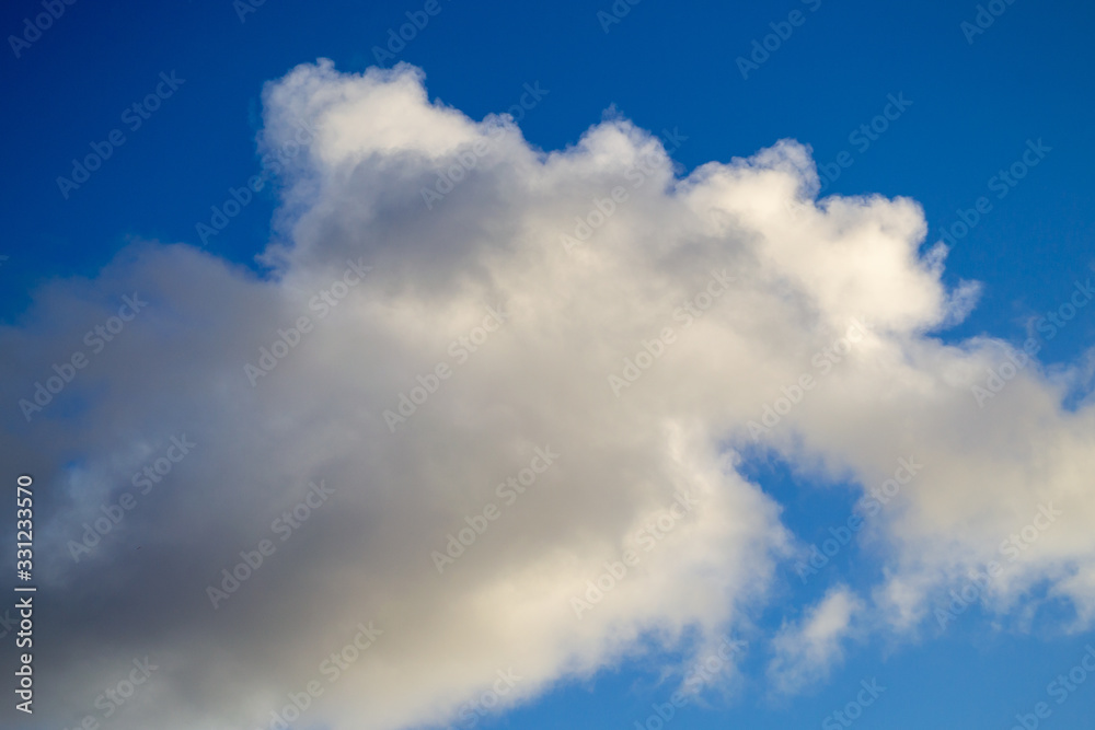Bright white with grey clouds on blue sky. Beautiful background.