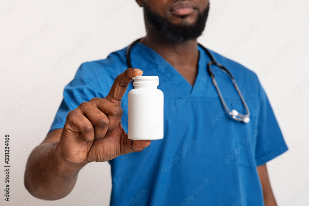 African american male doctor in blue uniform with pill bottle African american male doctor in blue uniform with pill bottle