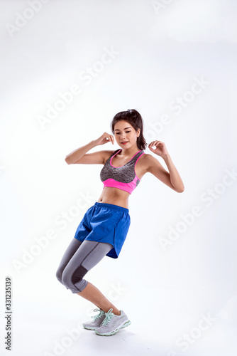 Young lady wearing exercise set twisted her body and kneel ,raise hands up in the air,show basic of dance workout,with happy feeling