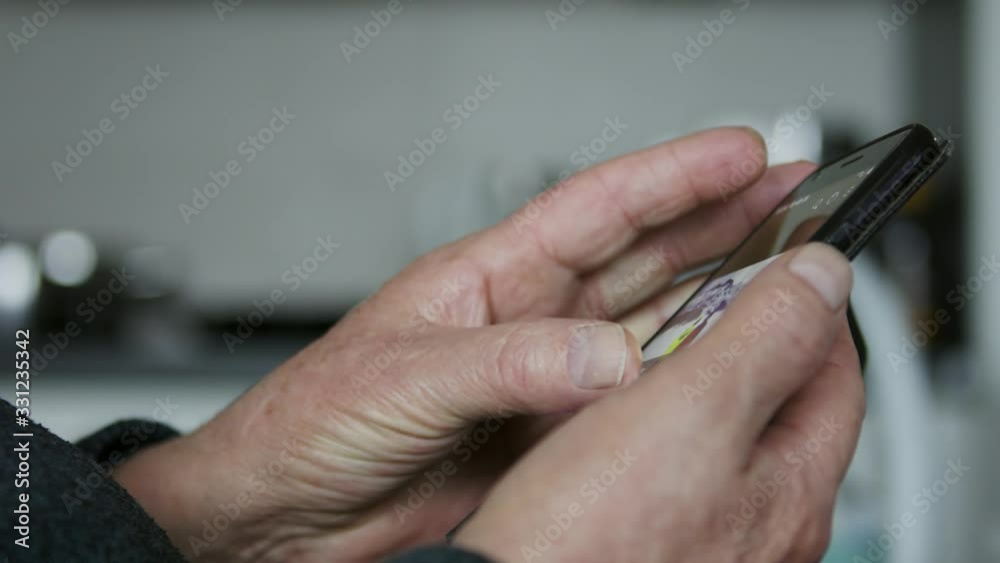 Close up. Wrinkled hands of an elderly person using the smartphone. Social distancing measures and online connection concept Close up. Wrinkled hands of an elderly person using the smartphone. Social distancing measures and online connection concept