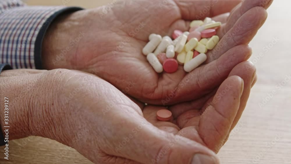Vitamins And Supplements. Closeup of the wrinkled hand of an elderly man holding a variety of pills on the palm. Vitamins And Supplements. Closeup of the wrinkled hand of an elderly man holding a variety of pills on the palm.