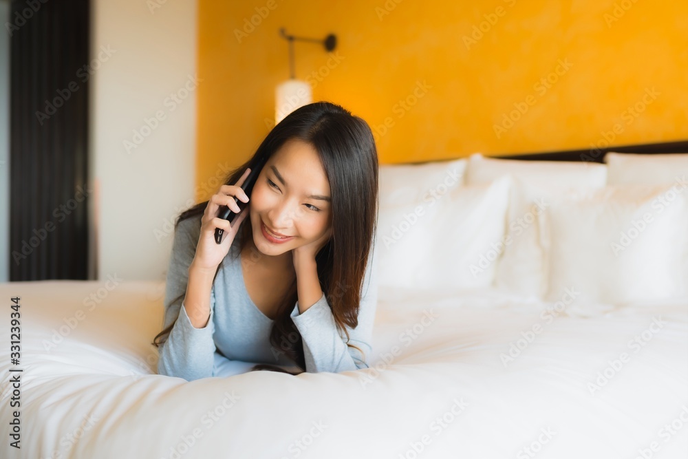 Portrait beautiful young asian woman using mobile cell phone on bed with coffee cup Portrait beautiful young asian woman using mobile cell phone on bed with coffee cup
