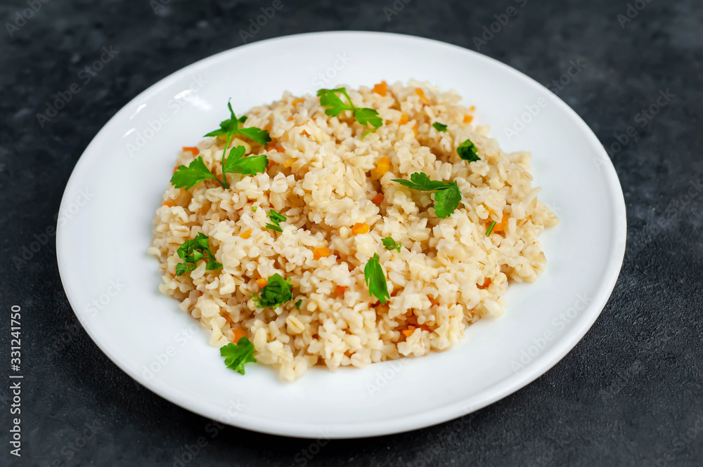 Bulgur with vegetables on a stone background. Healthy eating