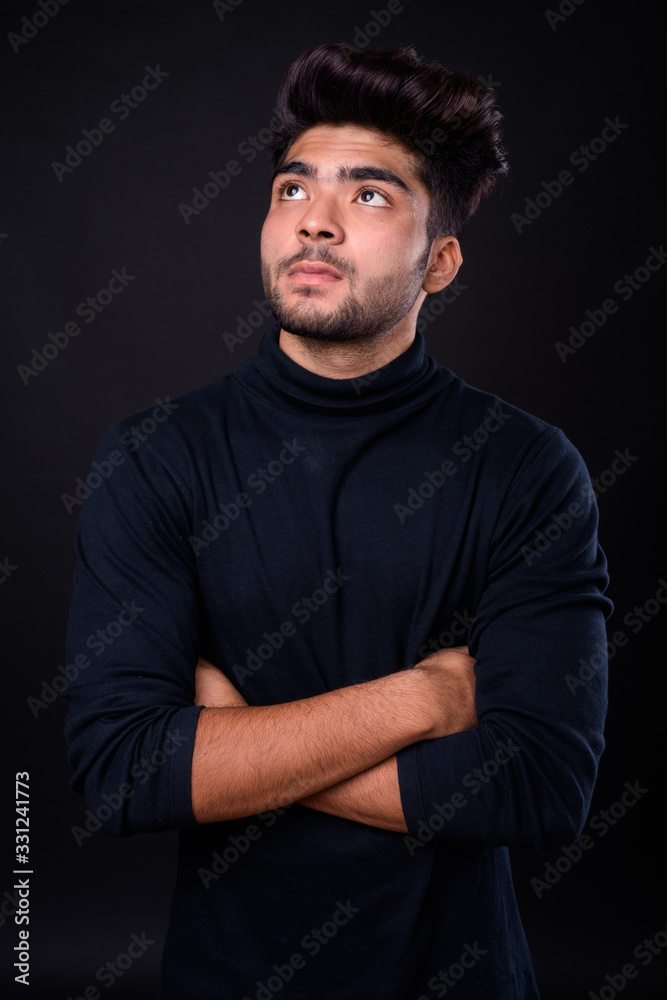 Young handsome Indian man against black background Young handsome Indian man against black background