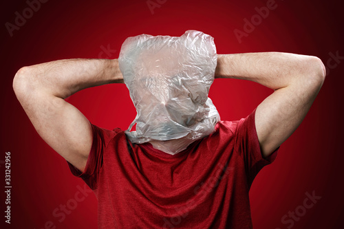 Photos The man holds his head in his hands, suffocating in a plastic bag