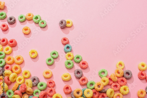Fototapeta Naklejka Na Ścianę i Meble -  top view of bright multicolored breakfast cereal on pink background