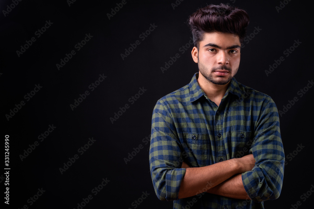 Young handsome Indian man against black background Young handsome Indian man against black background